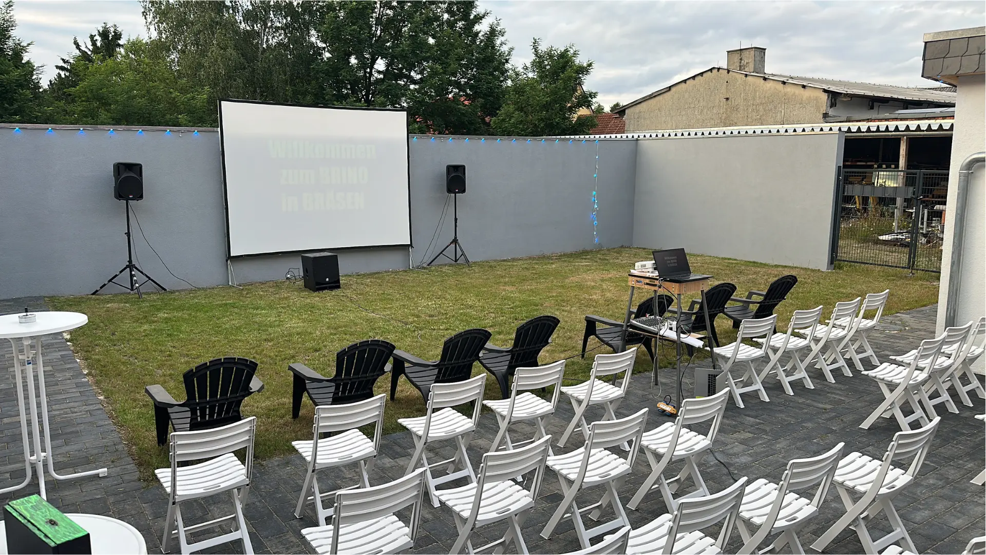 Sommerkino BRINO im Innenhof mit Leinwand, Boxen und Stuhlreihen im Freien